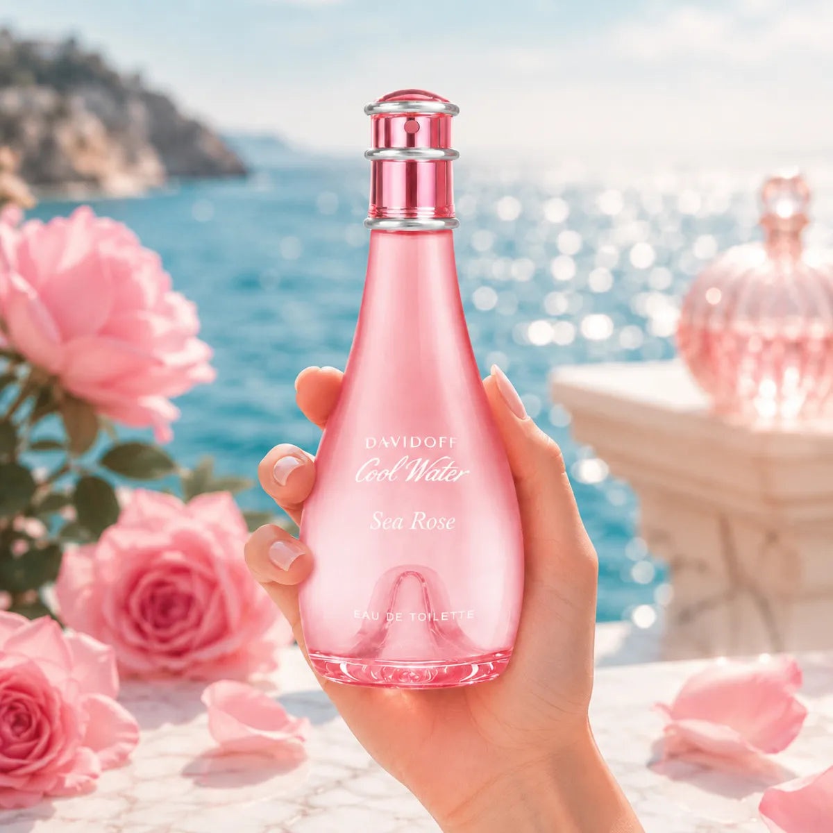 Hand elegantly holding the Davidoff Cool Water Sea Rose Eau de Toilette 100ml bottle against a soft ocean-inspired background with natural sunlight | Perfumesouq qatar