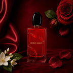 Luxury setup featuring the deep red glass bottle of Giorgio Armani Si Passione nestled among silk fabric folds, red rose petals, and white blossoms perfumesouq qatar