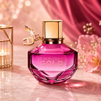 A woman holding the pink faceted bottle of Aigner Starlight Gold Eau de Parfum showcasing the signature gold star and letter charms from perfumesouq qatar